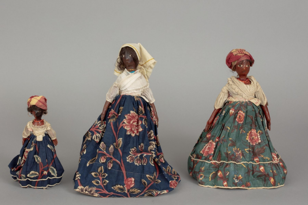 set of three black dolls depicted as wearing madras scarfs and clothing 